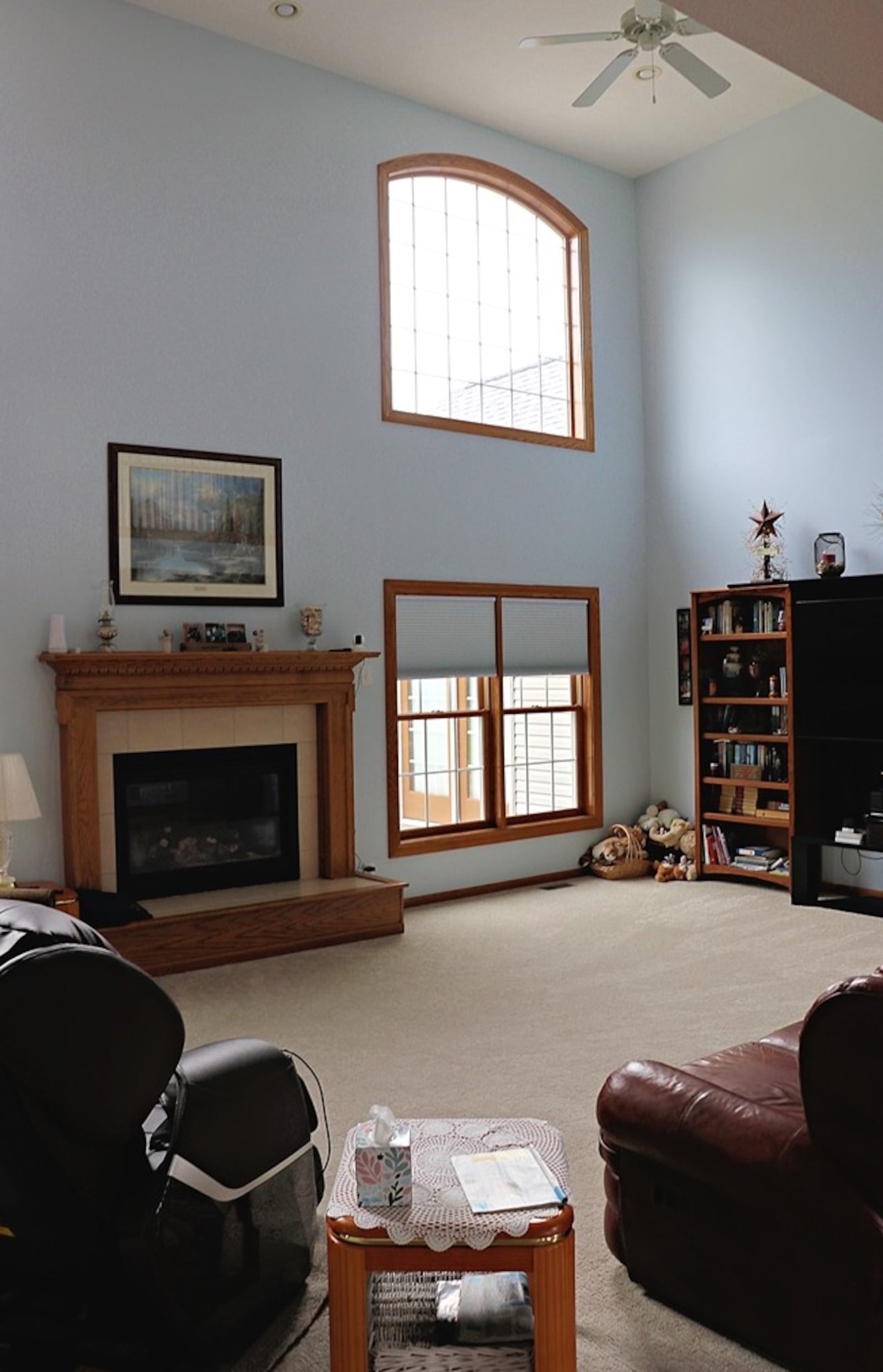 Off the dining room of this home for sale in Greene County, a two-story great room is filled with natural light through four picture windows that flank a gas fireplace. The fireplace has a raised hearth and a wood mantel surround. KATHY TYLER/CONTRIBUTED