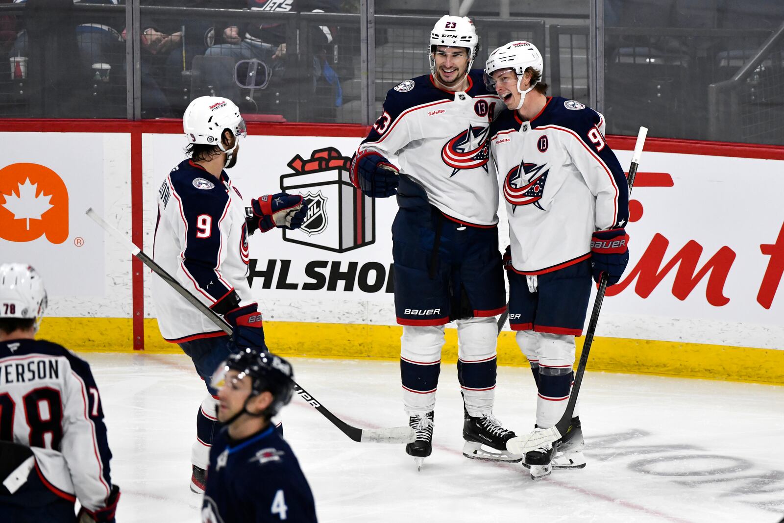 Columbus Blue Jackets' Kent Johnson, right, celebrates after his goal against the Winnipeg Jets with Sean Monahan (23) and Ivan Provorov (9) during third-period NHL hockey game action in Winnipeg, Manitoba, Sunday Dec. 8, 2024. (Fred Greenslade/The Canadian Press via AP)