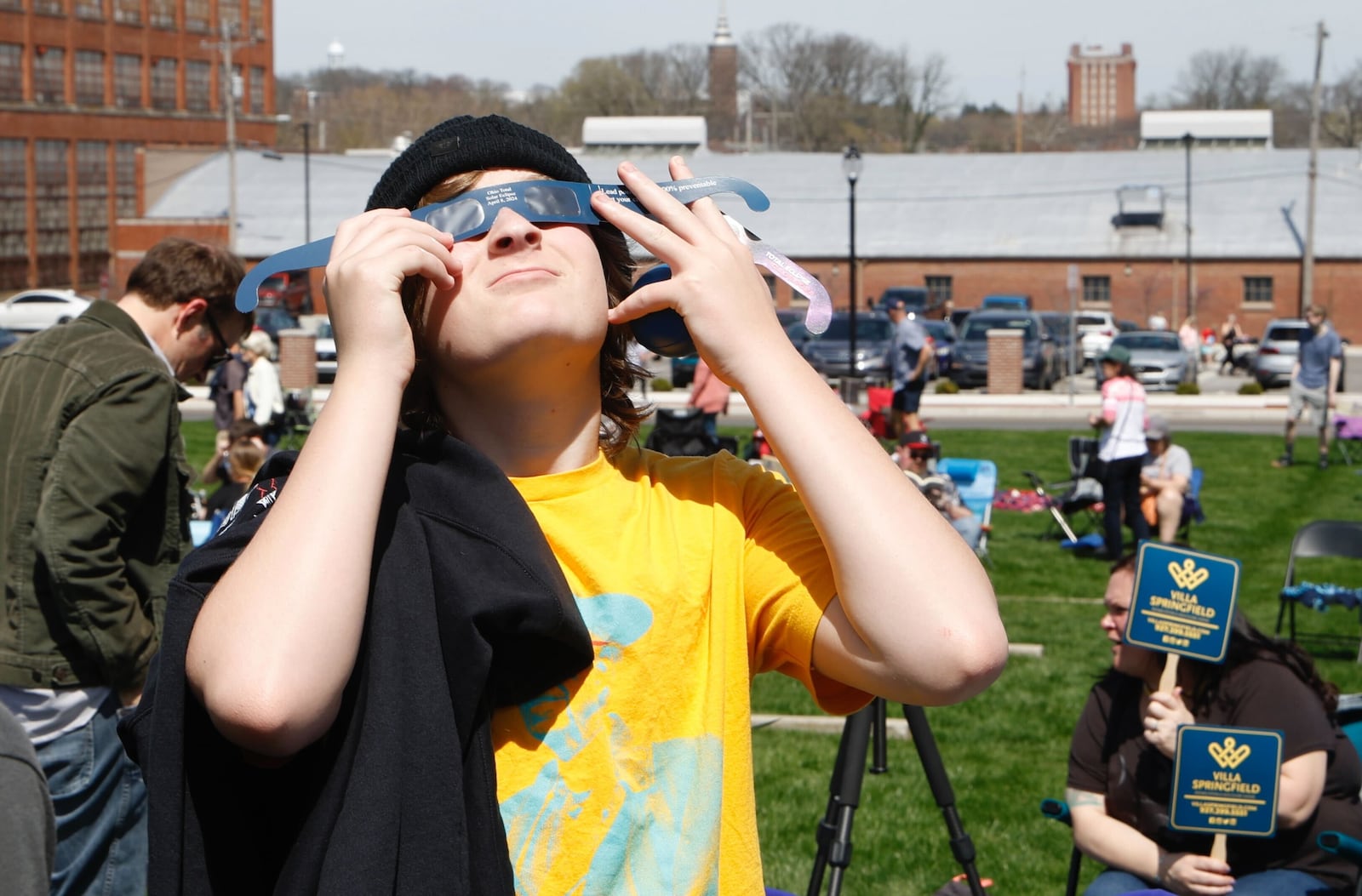 Anders Larson checks out a pair of eclipse glasses Monday, April 8, 2024, during the eclipse party at National Road Commons Park. BILL LACKEY/STAFF