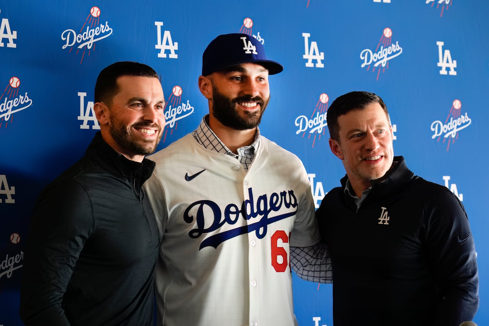 Los Angeles Dodgers new reliever Tanner Scott, center, poses for photos with Andrew Friedman, right, president of baseball operations for the Los Angeles Dodgers, right, and executive vice president and general manager Brandan Gomes during an introduction baseball news conference at Dodger Stadium in Los Angeles, Thursday, Jan. 23, 2025. (AP Photo/Richard Vogel)