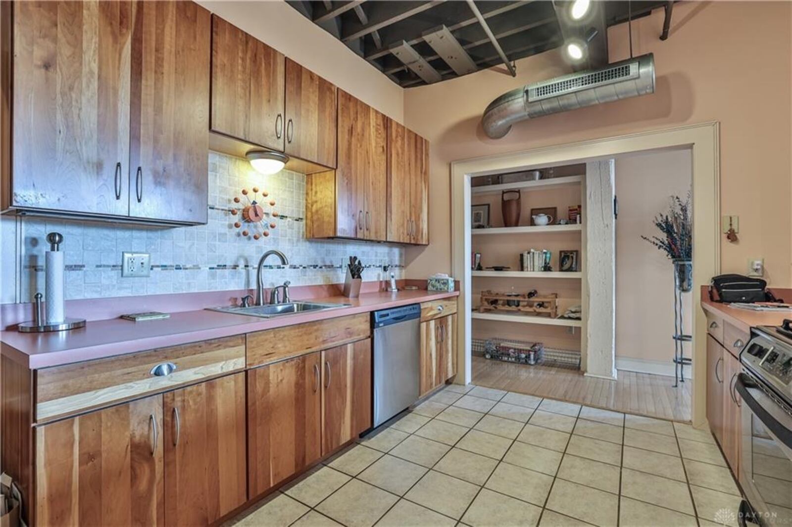 Ceramic-tile flooring fills the kitchen and contemporary wooden cabinetry wraps around three walls. CONTRIBUTED