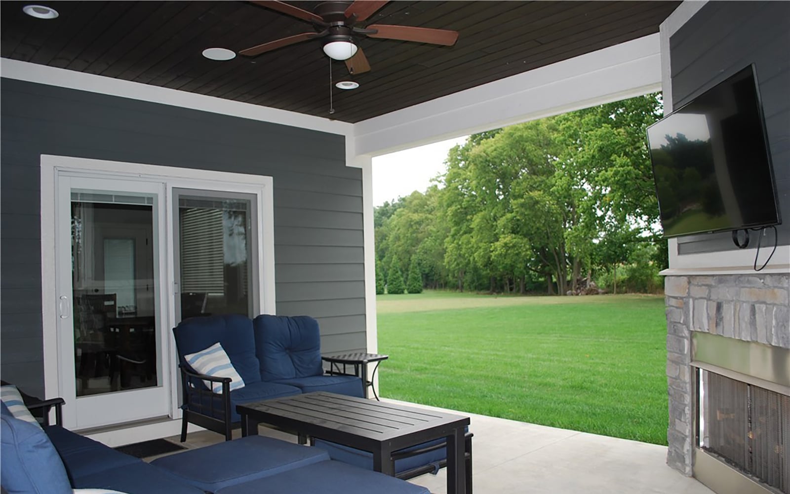 The covered patio on the rear of the home features a woodburning fireplace and outdoor television.