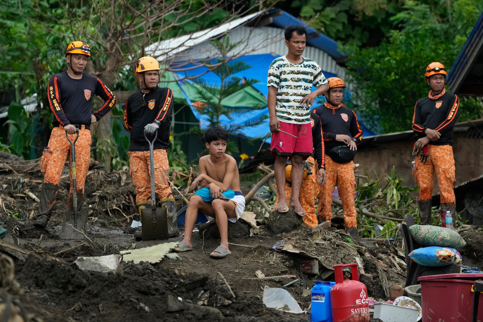 Rescuers and villagers watch retrieval operations on Saturday, Oct. 26, 2024 after it was struck by a landslide triggered by Tropical Storm Trami in Talisay, Batangas province, Philippines. (AP Photo/Aaron Favila)