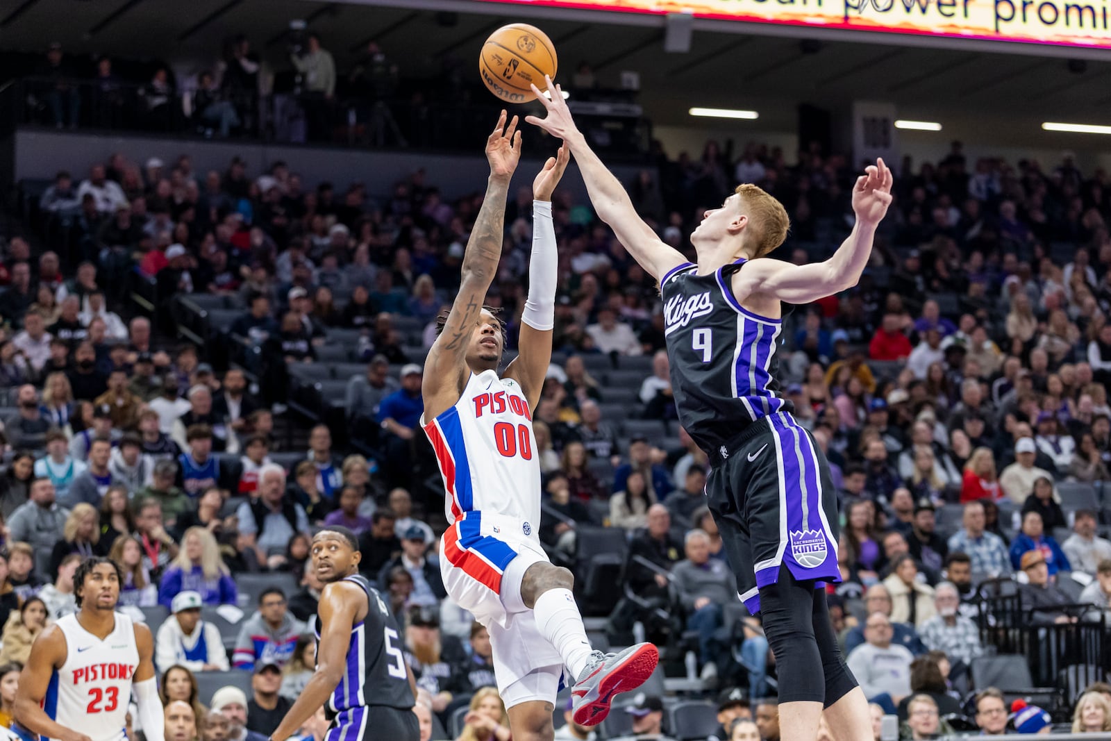 Detroit Pistons forward Ronald Holland II (00) attempts to shoot over Sacramento Kings guard Kevin Huerter (9) during the first half of an NBA basketball game Thursday, Dec. 26, 2024, in Sacramento, Calif. (AP Photo/Sara Nevis)