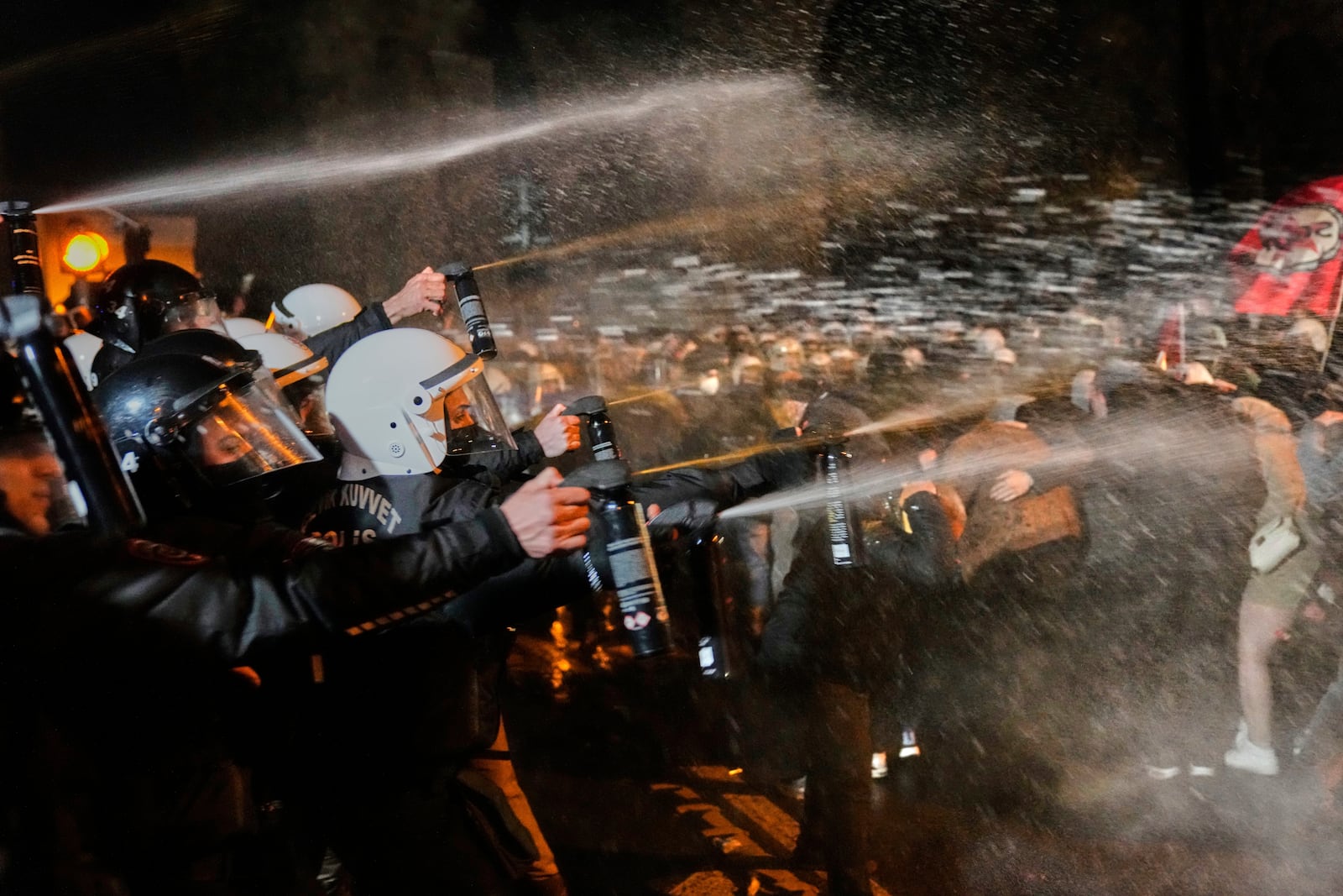 Police officers use pepper spray during clashes with people as they protest against the arrest of Istanbul's Mayor Ekrem Imamoglu, in Istanbul, Turkey, Friday, March 21, 2025. (AP Photo/Khalil Hamra)