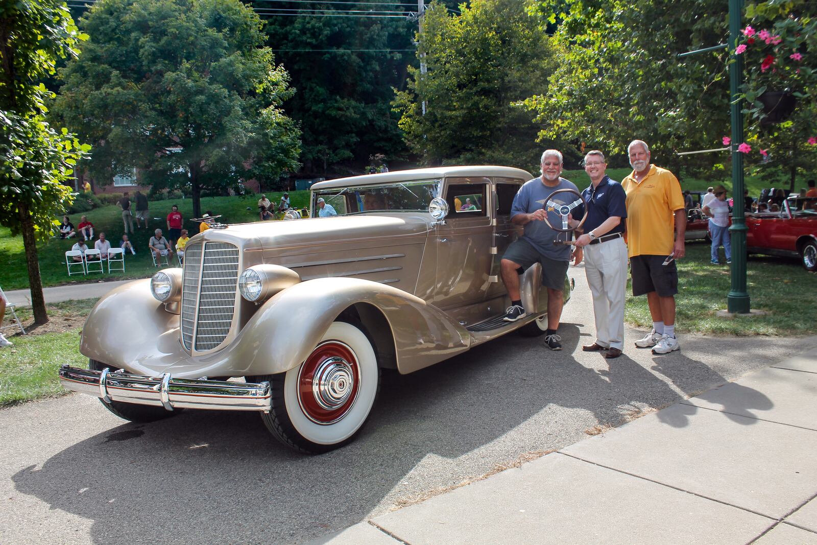 Greg Ornazian's beautiful gold 1929 Duesenberg J Bohman & Schwartz sedan was awarded the R. H. Grant Best of Show Award presented by AAA. From left, Greg Ornazian, Thomas Vaughn, AAA Regional President and Paul Rich, the creator of the award.  Photo by Haylie Schlater