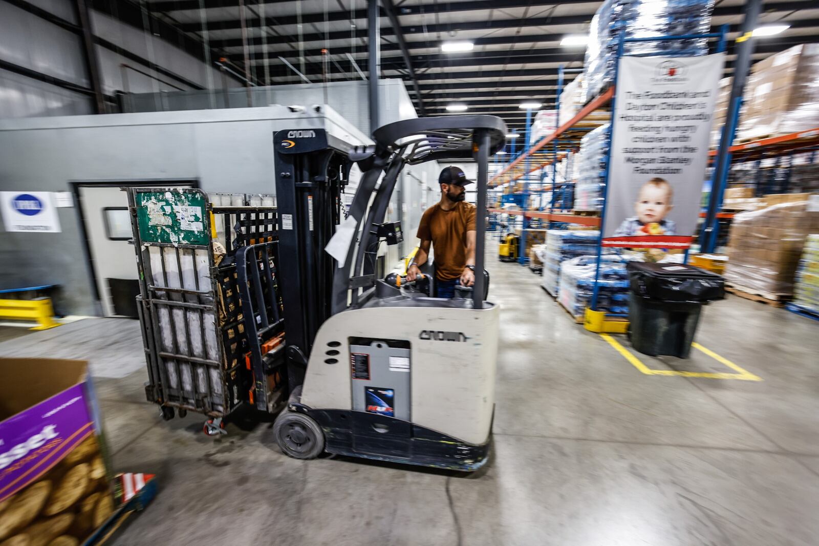 Foodbank Community Relations Liaison, Brandon Kunkle moves box of food around the Foodbank Inc. in Dayton Monday May 16, 2022. Food prices are increasing because of inflation making it challenging for foodbanks and soup kitchens to keep up. JIM NOELKER/STAFF