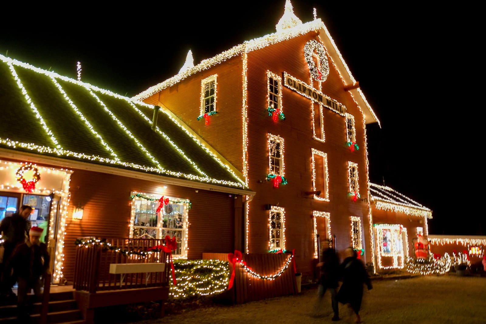 Visitors take in the Legendary Lights at the historic Clifton Mill, just outside Yellow Springs, Friday, Dec. 2, 2022. The mill, built in 1802 and still a working, has become a Miami Valley institution around the holidays. GREG LYNCH / STAFF