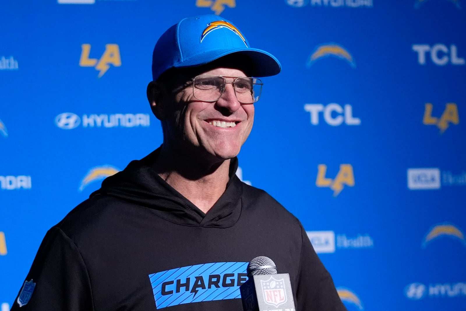 Los Angeles Chargers head coach Jim Harbaugh listens to a reporter's question during a news conference following an NFL football game, Saturday, Dec. 28, 2024, in Foxborough, Mass. (AP Photo/Robert F. Bukaty)