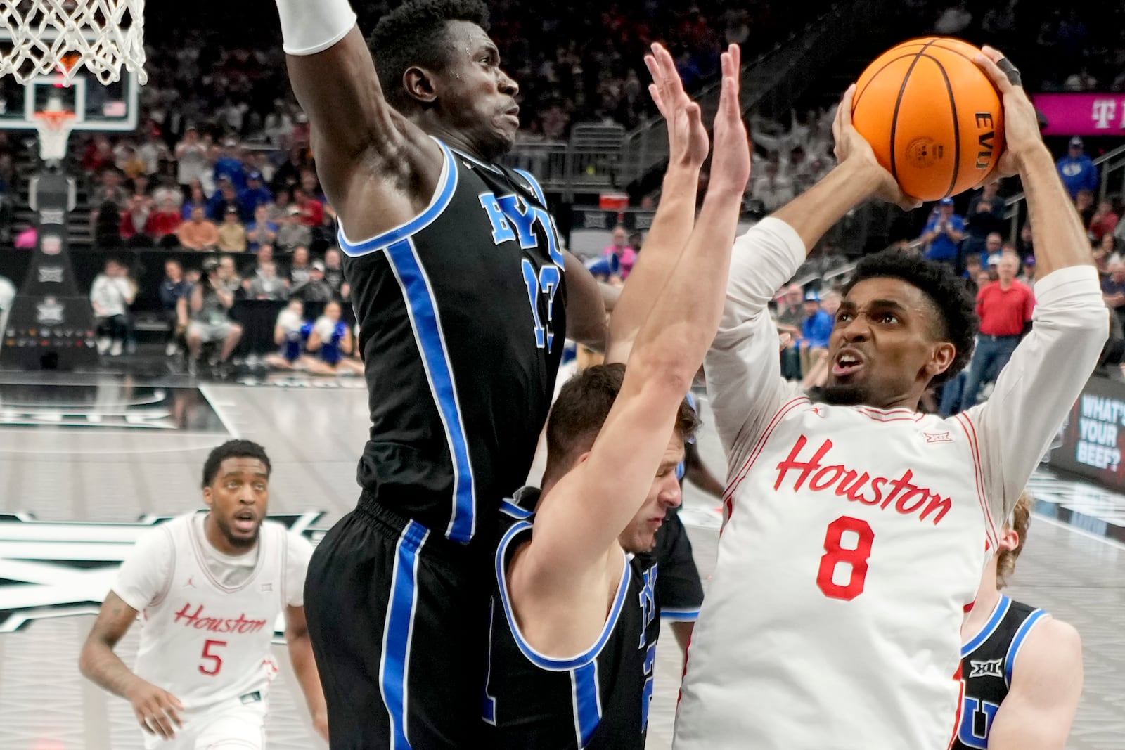 Houston guard Mylik Wilson (8) looks to shoot over Brigham Young center Keba Keita (13) and guard Trevin Knell, center, during the first half of a semifinal NCAA college basketball game in the Big 12 men's tournament Friday, March 14, 2025, in Kansas City, Mo. (AP Photo/Charlie Riedel)