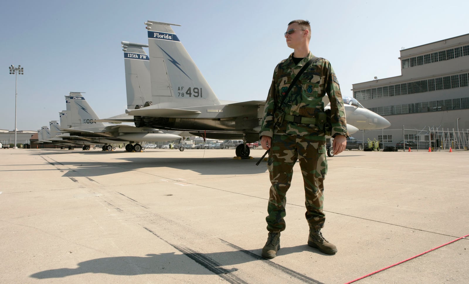 SSgt. Glenn Fritch with the 125th Security Forces Squadron from the Florida Air National Guard watches over the 13 F-15 Eagles flown to 
Wright-Patterson Air Force Base until Tropical Storm Hanna passes by Florida.  Base Spokesman Derek Kaufman exects more airplanes including F-15E Strike Eagles form Seymour Johnson AFB in North Carolina and C-17 Globemasters from Charleston AFB in South Carolina on Friday.  Staff photo by Ty Greenlees.