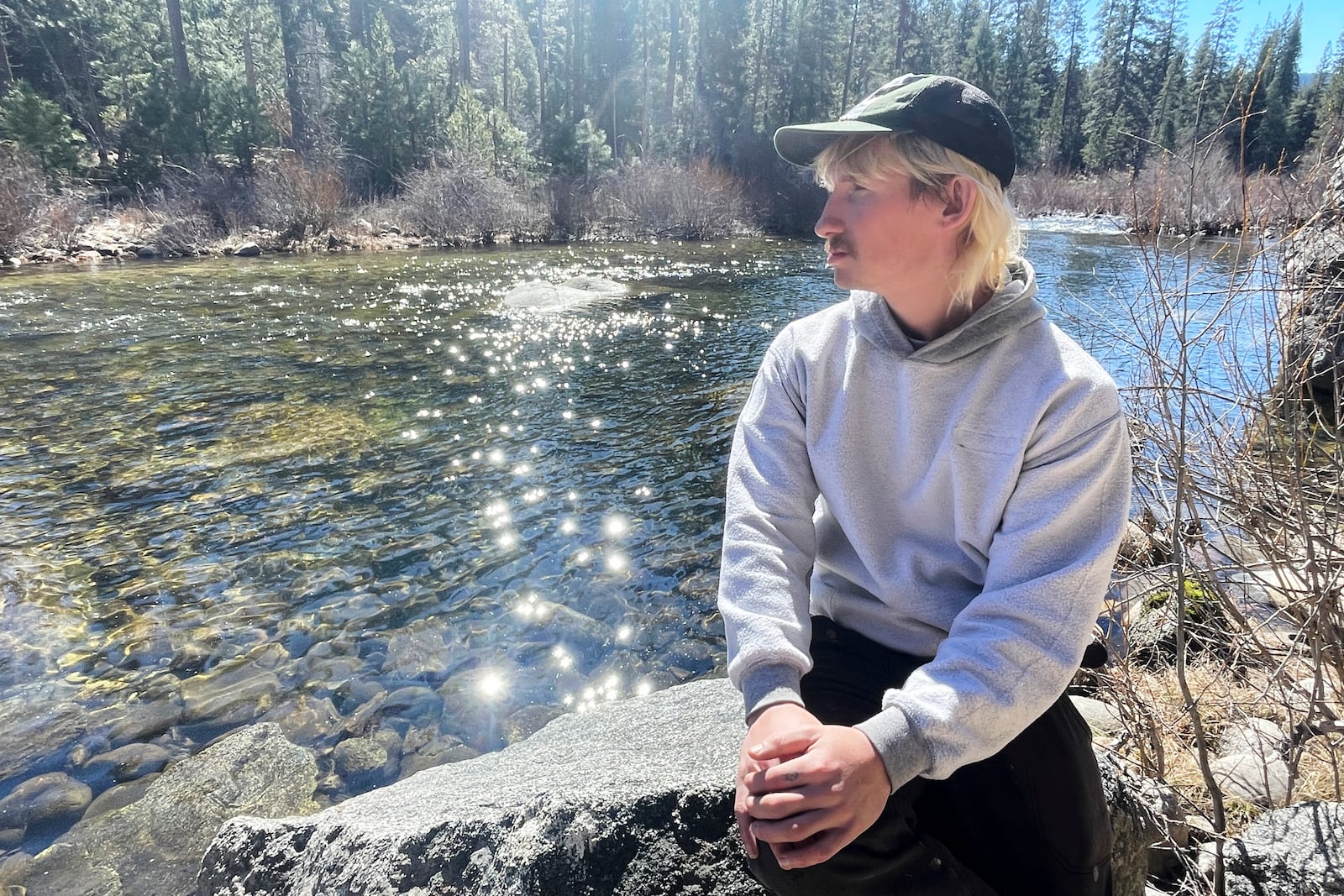 Aleksander Chmura, who was dismissed from his job as a park custodian, sits along a creek Thursday, Feb. 20, 2025, in Yosemite National Park, Calif. (AP Photo/Haven Daley)