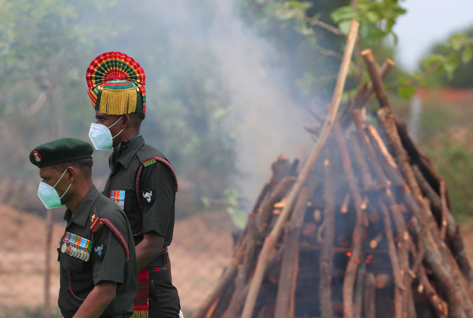 FILE- In this June 18, 2020 file photo, Indian army officers walk past the pyre of their colleague Colonel B. Santosh Babu, who was killed during a clash with Chinese soldiers in Ladakh region, during his funeral at Suryapet, about 140 kilometers (87.5 miles) from Hyderabad, India. Tensions along the disputed India-China border seem to be getting worse rather than better, three months after their deadliest confrontation in decades in June. The Asian giants accused each other this week of sending soldiers into each other’s territory and fired warning shots for the first time in 45 years, raising the specter of full-scale military conflict. (AP Photo/Mahesh Kumar A, File)