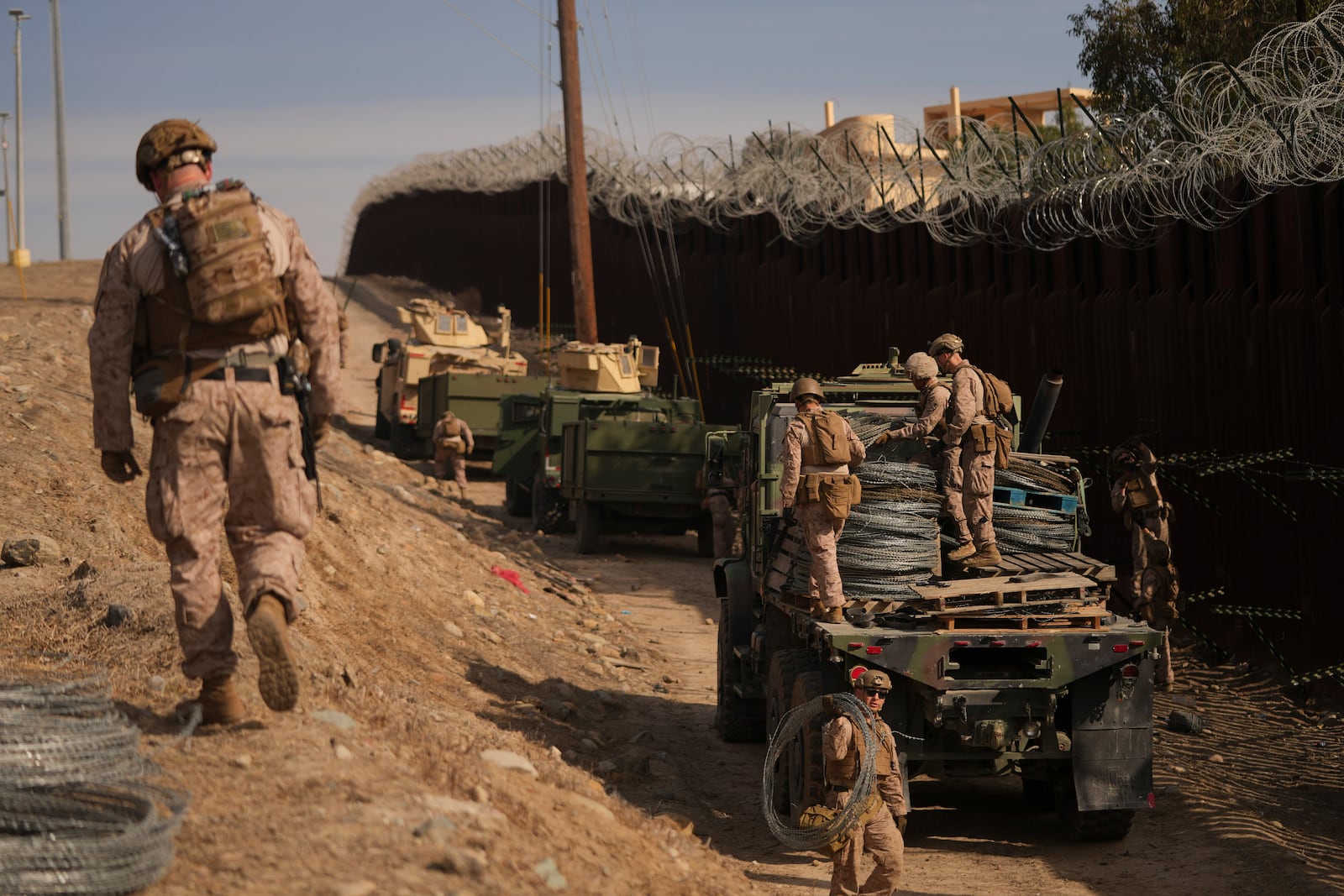 U.S. Marines install barbed wire along the border fence Friday, Jan. 31, 2025, in San Diego. (AP Photo/Jae C. Hong)