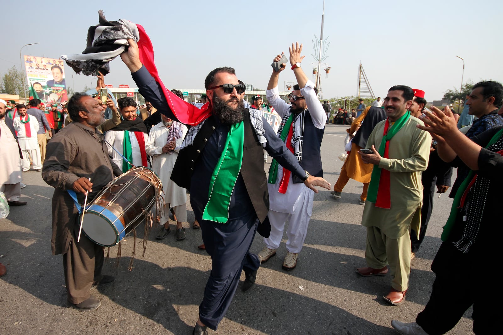 Supporters of imprisoned former premier Imran Khan's Pakistan Tehreek-e-Insaf party, dance before starting a rally for Islamabad to demand Khan's release, in Peshawar, Pakistan, Sunday, Nov. 24, 2024. (AP Photo/Muhammad Sajjad)