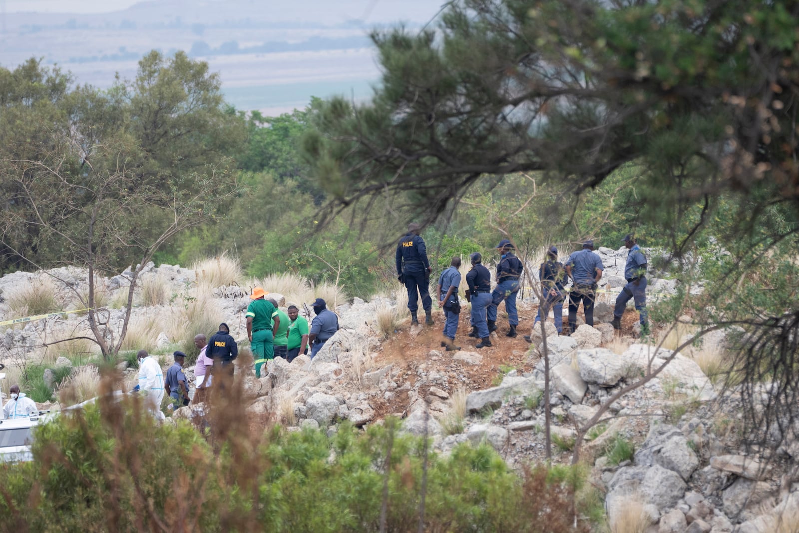 Rescue workers, bottom left, remove a body from a reformed mineshaft where illegal miners are trapped inside a disused mine in Stilfontein, South Africa, Thursday, Nov.14, 2024. (AP Photo/Jerome Delay)