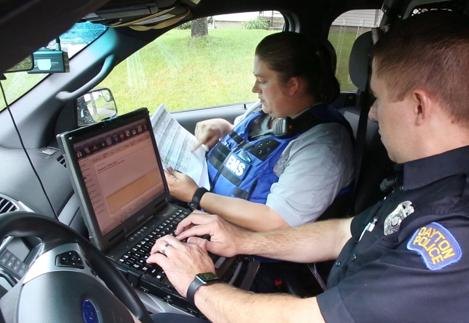 Dayton Fire Department Addiction Resource Liaison/EMT Amy Dunkin, left, and Dayton Police Addiction Liaison Officer Jason Olson map out their day connecting with opioid addicts to assist them with finding treatment. TY GREENLEES / STAFF