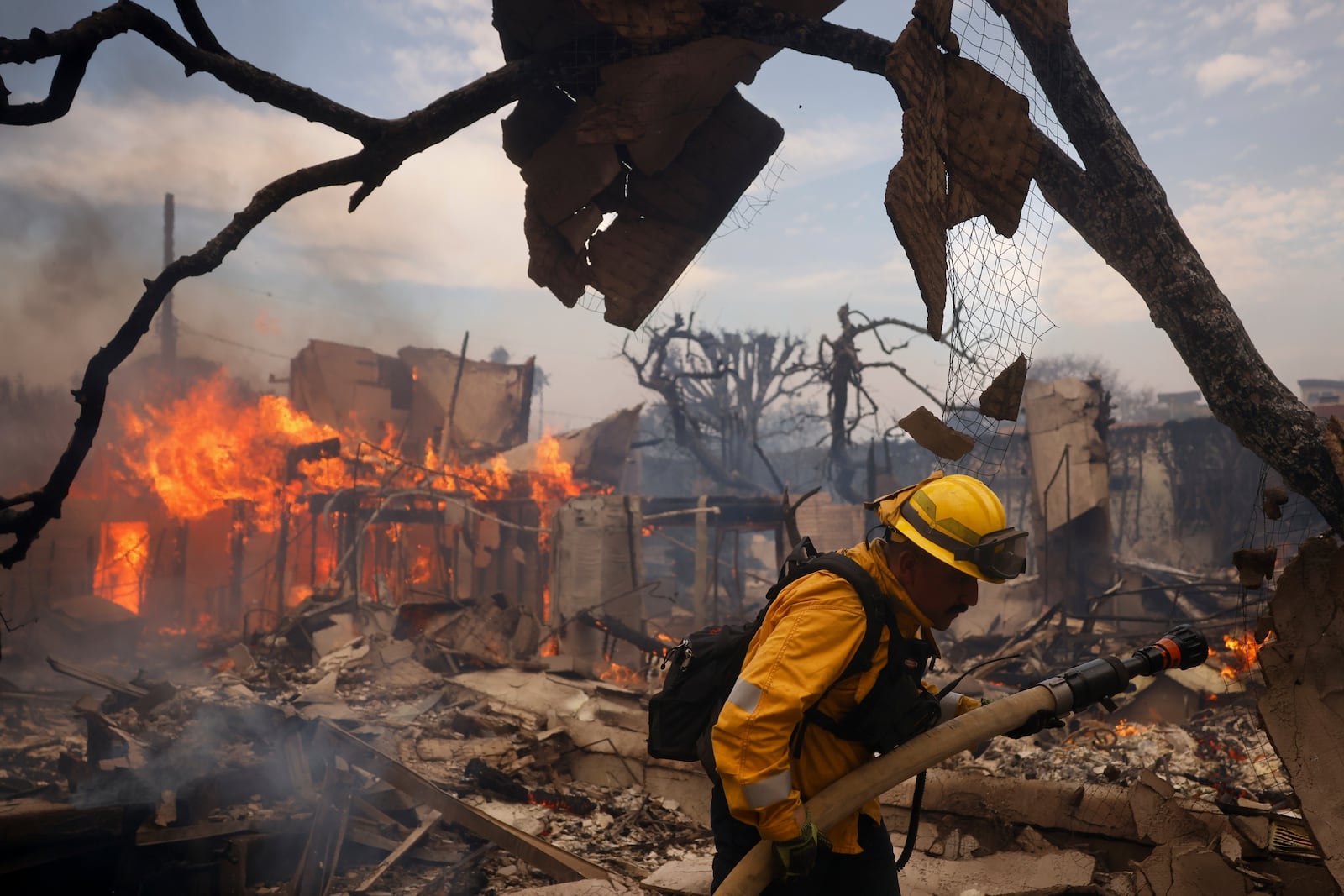 FILE - A firefighter battles the Palisades Fire around a burned structure in the Pacific Palisades neighborhood of Los Angeles, Jan. 8, 2025. (AP Photo/Etienne Laurent, File)