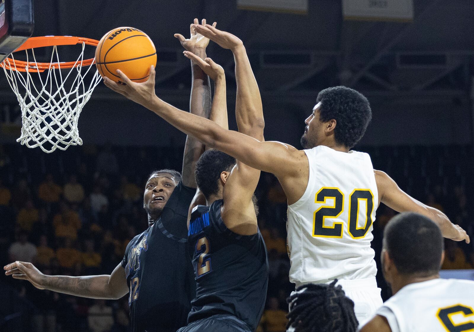 Wichita State's Harlond Beverly, right, shoots against Memphis defenders Dain Dainja, left, and Nicholas Jourdain during the first half of an NCAA college basketball game, Sunday, Feb. 16, 2025, in Wichita, Kan. (AP Photo/Travis Heying)