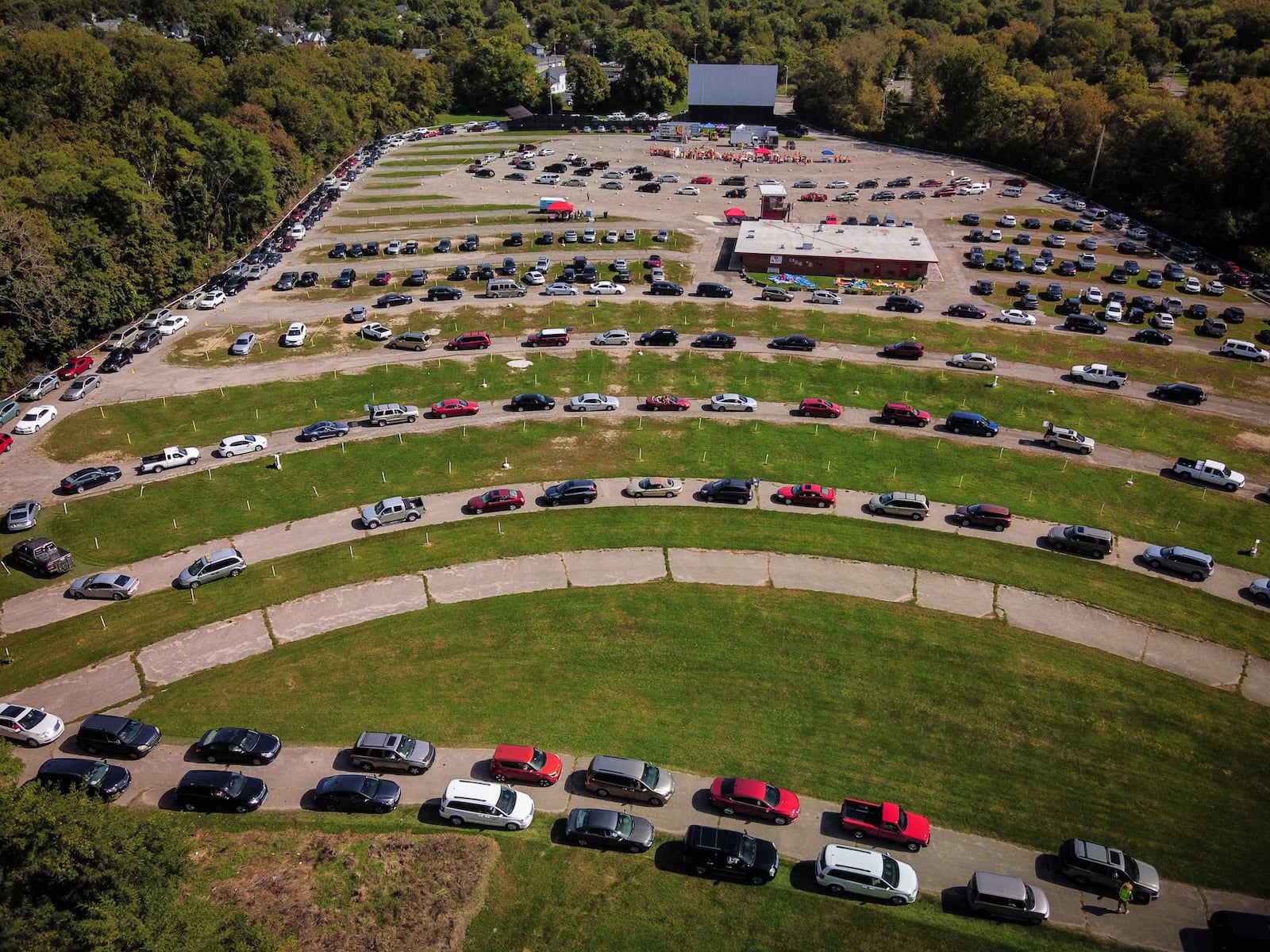 Vehicles line up at a mass food distribution at the Dixie Twin Drive-In in Harrison Twp. on Thursday, Sept. 30, 2021. Lee Lauren Truesdale, chief development officer at The Foodbank Inc., said they're expecting 500 to 700 households to attend. STAFF / JIM NOELKER