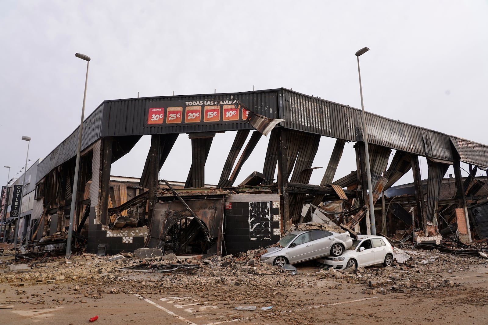 Damaged cars are seen outside a shopping centre after floods in Valencia, Spain, Friday, Nov. 1, 2024. (AP Photo/Alberto Saiz)