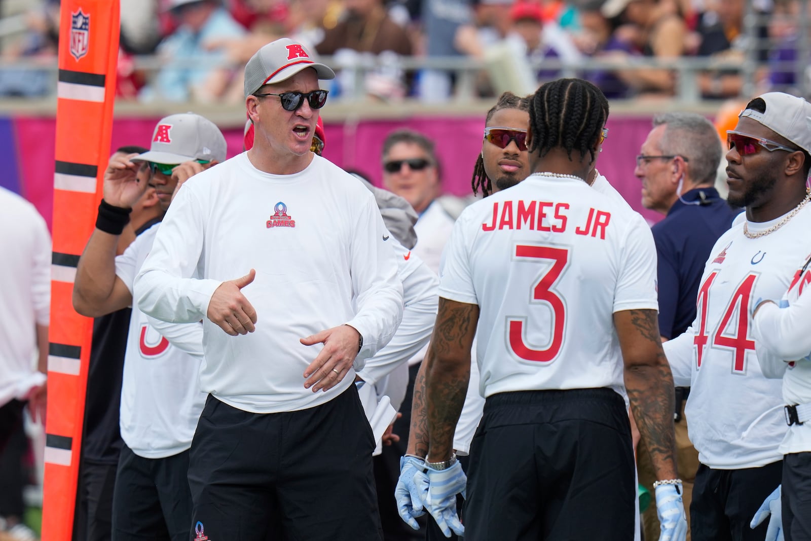 AFC coach Peyton Manning, left, talks to players before the flag football event at the NFL Pro Bowl, Sunday, Feb. 2, 2025, in Orlando. (AP Photo/Chris O'Meara)