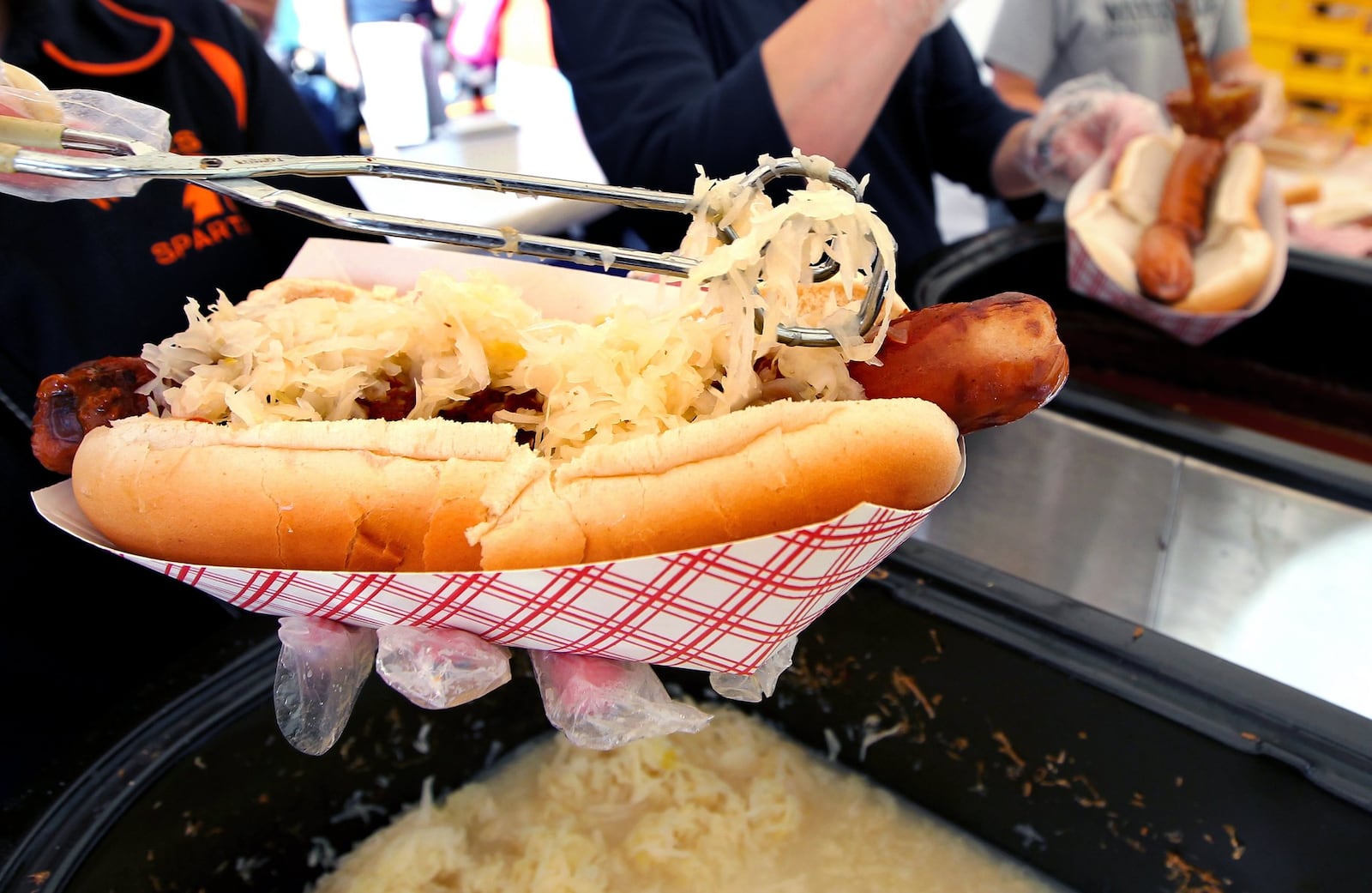 A giant hot dog is topped with sauerkraut at the Hawg Dawgs booth, supporting the Waynesville High School’s athletic boosters, during the Sauerkraut Festival in Waynesville. NICK DAGGY / STAFF