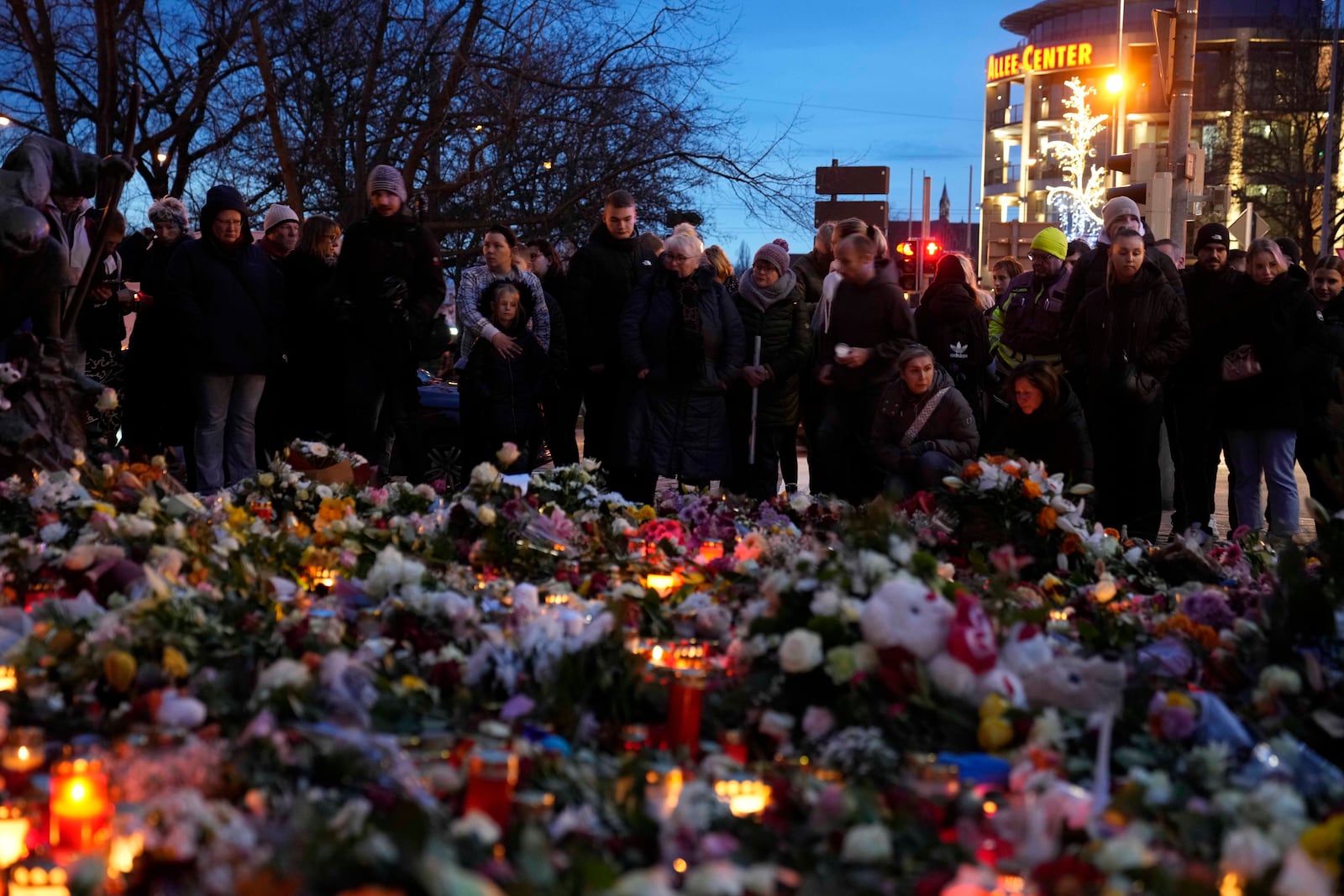 Citizens pay tribute for deaths outside St. John's Church near a Christmas Market, where a car drove into a crowd on Friday evening, in Magdeburg, Germany, Saturday, Dec. 21, 2024. (AP Photo/Ebrahim Noorozi)