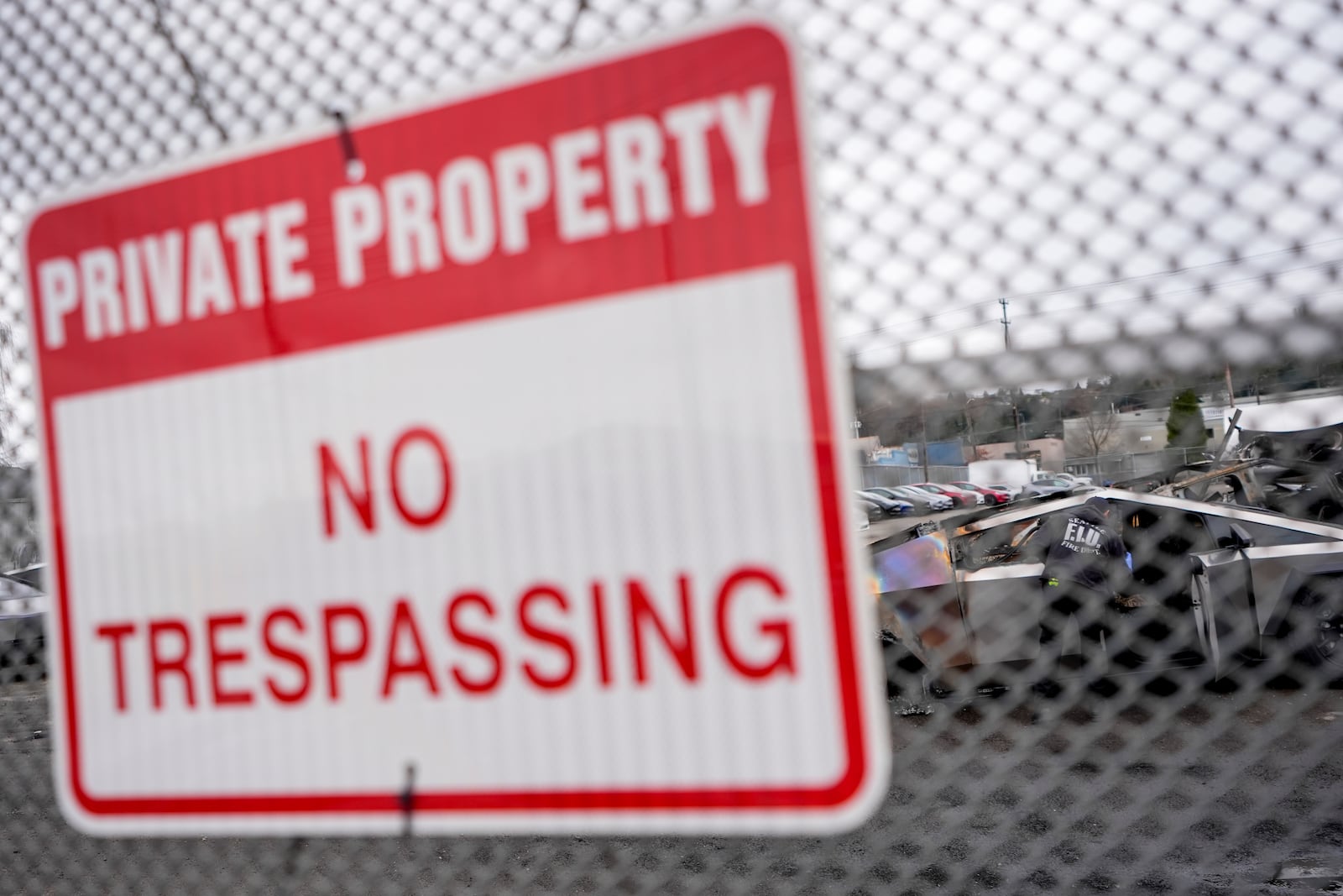 A sign hangs at the Tesla lot where Tesla Cybertrucks burned in Seattle, Monday, March 10, 2025. (AP Photo/Lindsey Wasson)