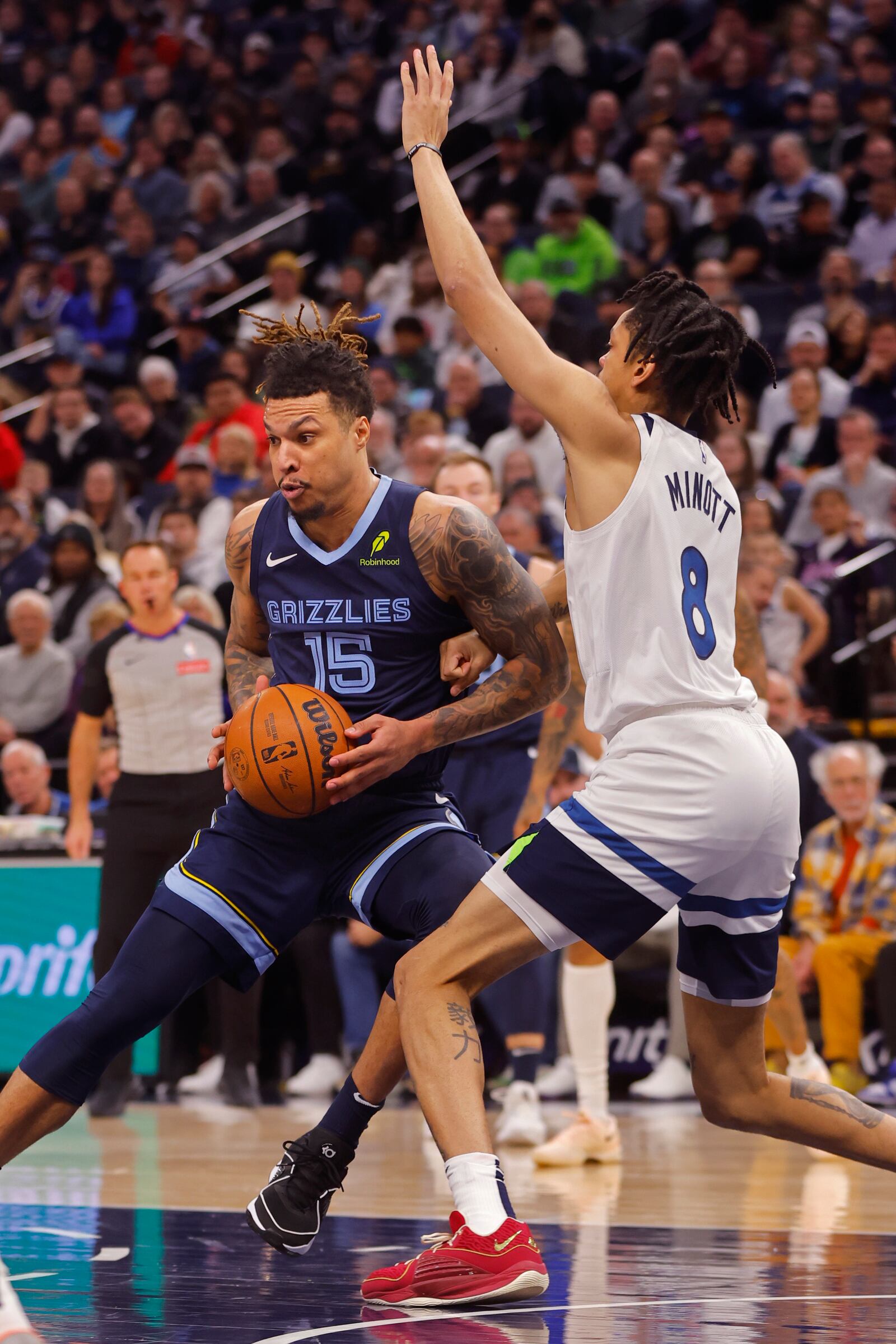 Minnesota Timberwolves forward Josh Minott (8) fouls Memphis Grizzlies center Brandon Clarke (15) in the first quarter of an NBA basketball game Saturday, Jan. 11, 2025, in Minneapolis. (AP Photo/Bruce Kluckhohn)