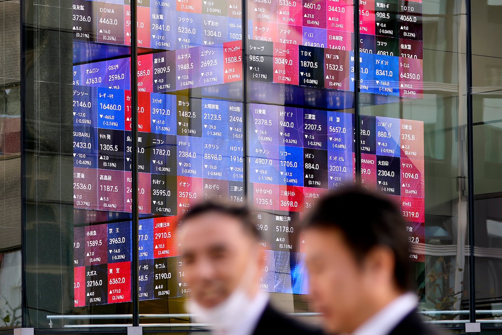 People walk past an electronic stock board showing Japan's stock prices Thursday, Nov. 28, 2024 in Tokyo.(AP Photo/Shuji Kajiyama)