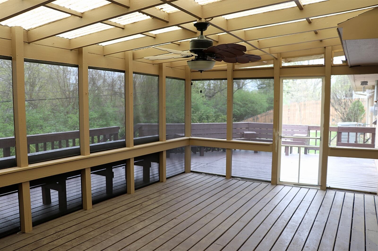 Sliding patio doors off the family room open out to a screen-enclosed deck. The awning covering allows for some sunlight into the enclosed area and there is a ceiling paddle fan.