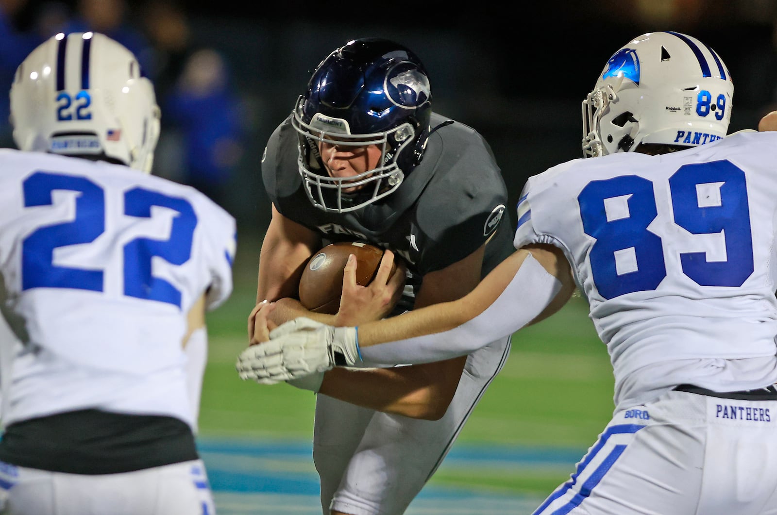 Fairmont's Brock Baker carries the ball between Springboro's Nolan Stringer, left, and Luke Cheatwood. BILL LACKEY/STAFF