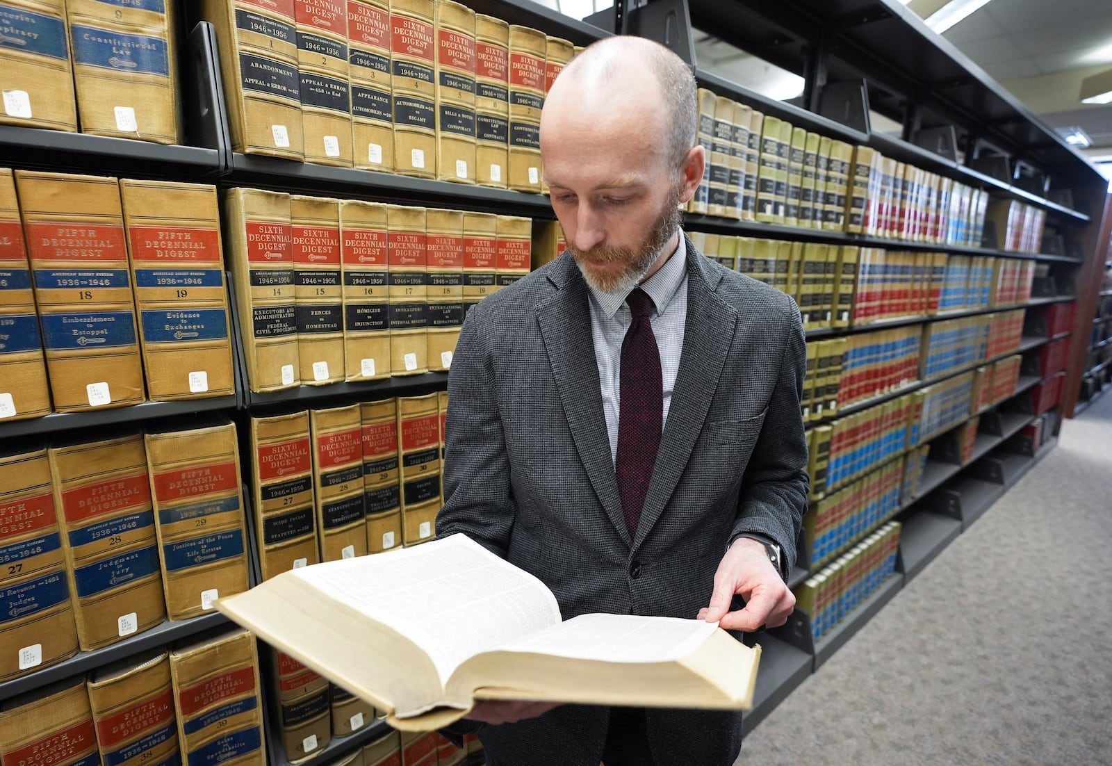 Michigan State University Associate Professor of Law Justin Simard looks up information in the School of Law library, Tuesday, Feb. 18, 2025 in East Lansing, Mich. (AP Photo/Paul Sancya)