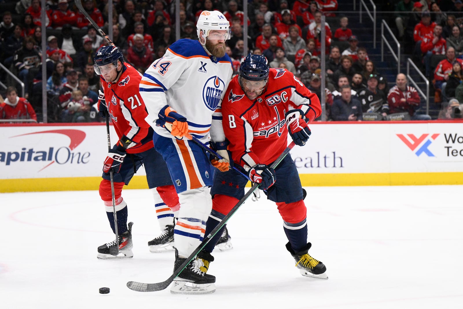 Washington Capitals left wing Alex Ovechkin (8) battles for the puck against Edmonton Oilers defenseman Mattias Ekholm (14) during the first period of an NHL hockey game, Sunday, Feb. 23, 2025, in Washington. (AP Photo/Nick Wass)