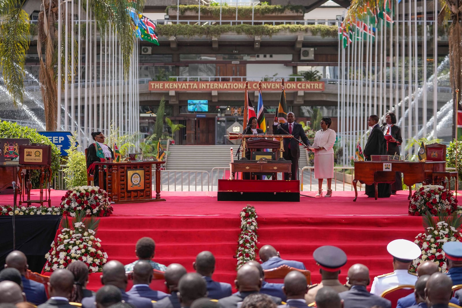 Kenya's new Deputy President Kithure Kindiki, center, is sworn into office as his wife Joyce Kithure, center right, holds the Bible at a ceremony held at Kenyatta International Convention Centre, in Nairobi, Kenya Friday, Nov. 1, 2024. (AP Photo/Brian Inganga)