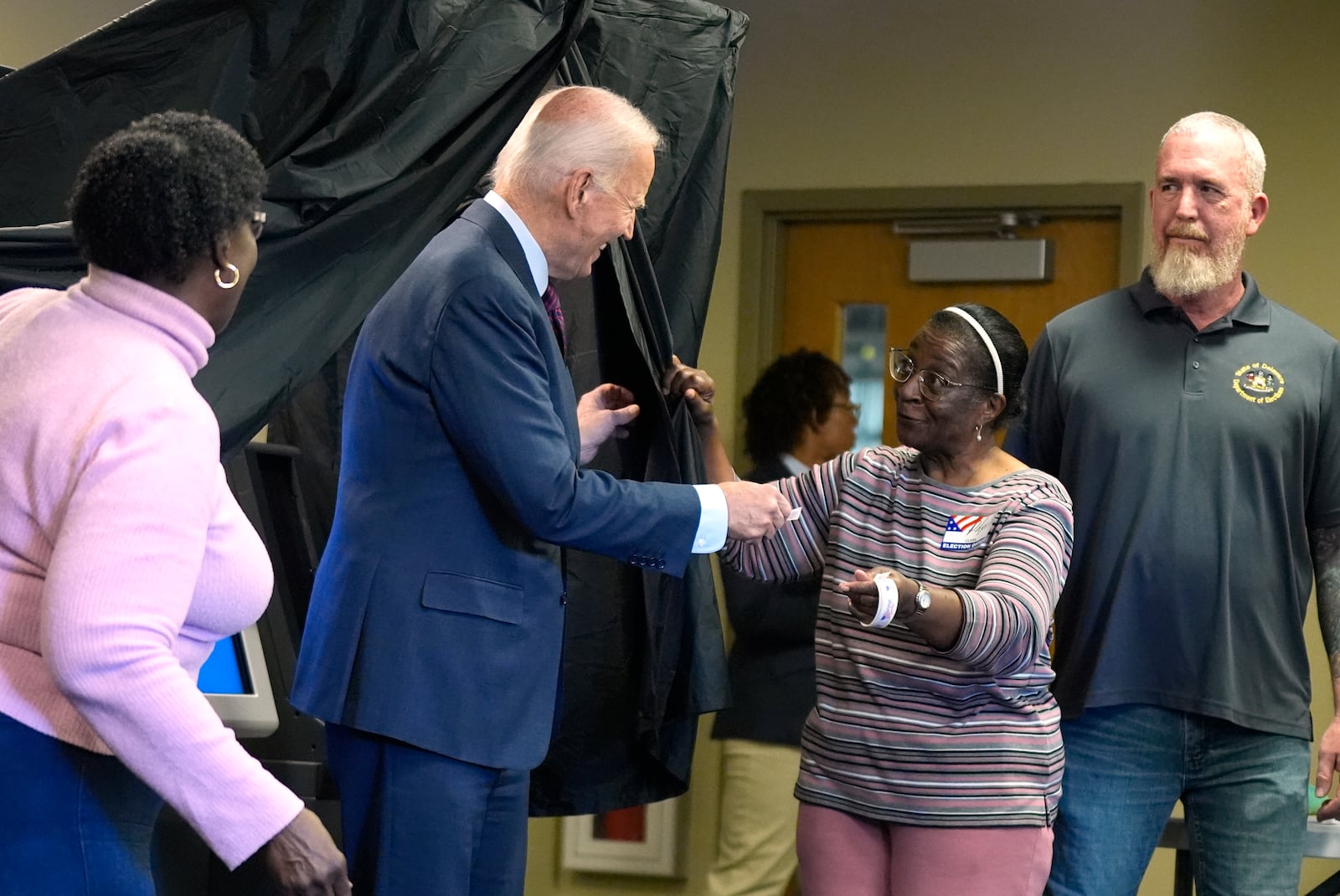 President Joe Biden is handed an "I Voted Early" sticker upon exiting the voting booth after casting his early-voting ballot for the 2024 general elections, Monday, Oct. 28, 2024, in New Castle, Del. (AP Photo/Manuel Balce Ceneta)