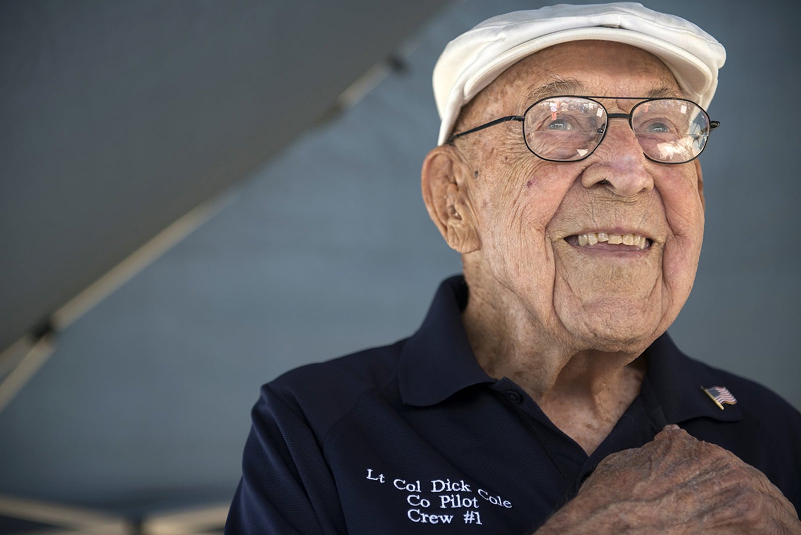 U.S. Air Force Retired Lt. Col. Richard E. Cole, Co-Pilot to Jimmy Doolittle during the Doolittle Raid, smiles as he honors the U.S. flag during the singing of the national anthem at an airshow in Burnet, Texas. Lt. Col. Cole was honored by the community and guests as the only remaining military service member alive from the April 18, 1942 Doolittle Raid. (U.S. Air Force photo by Staff Sgt. Vernon Young Jr.)