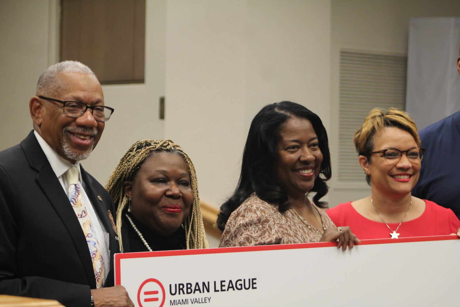 Dayton Mayor Jeffrey Mims Jr. and Nikol Miller and Utsey Shelton with the Miami Valley Urban League present an oversized check to Paula Cooks, who owns Now and Zen DIY Studio in downtown Dayton with her daughter, Alleah Cooks. Now and Zen was one of 24 recipients of a new micro-grant program benefitting small minority- and women-owned businesses. CORNELIUS FROLIK / STAFF