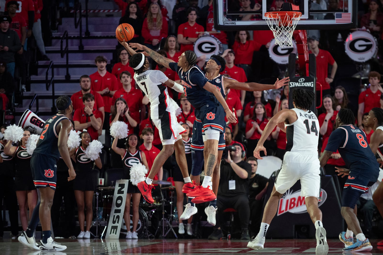 Georgia guard Tyrin Lawrence (7) shoots the ball over Auburn center Dylan Cardwell (44) and Auburn forward Jahki Howard (3) during the first half of an NCAA college basketball game, Saturday, Jan. 18, 2025, in Athens, Ga. (AP Photo/Kathryn Skeean)