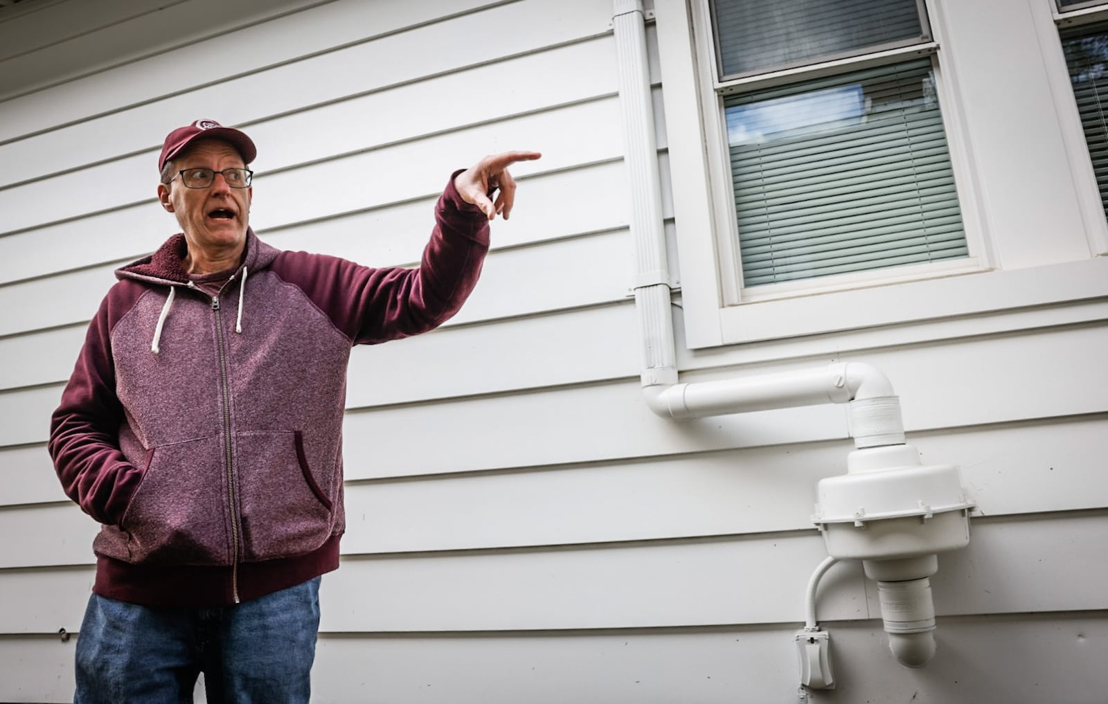 Jerry Bowling, III, president of the McCook Field Neighborhood Association points out a vapor intrusion mitigation system, which removes potentially toxic chemicals that seep into residents basements. JIM NOELKER/STAFF