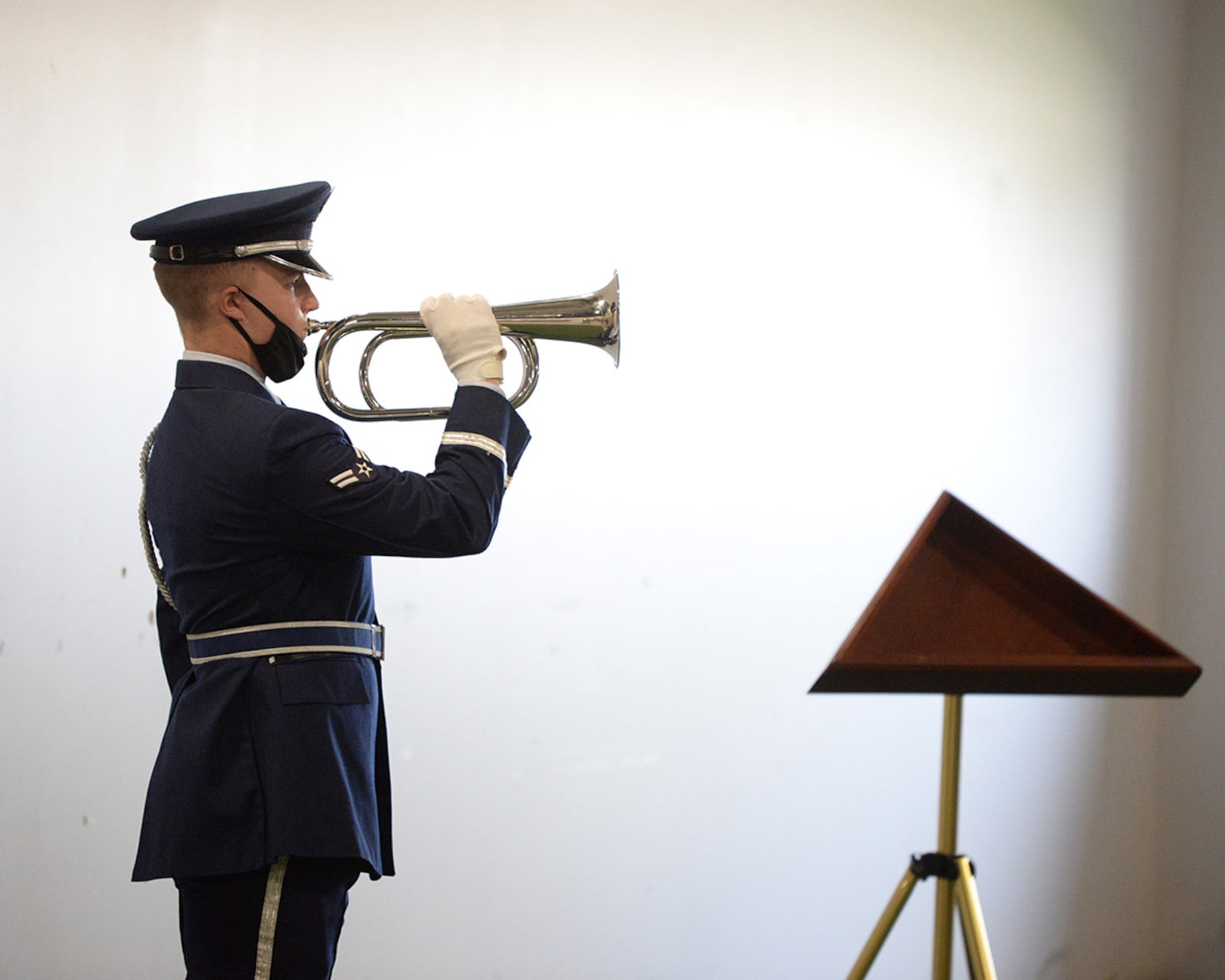 Airman 1st Class Blake Cassick plays taps before ceremonial guardsmen demonstrate the six-man flag fold during the graduation ceremony of 28 new Honor Guard members April 20. U.S. AIR FORCE PHOTO/TY GREENLEES