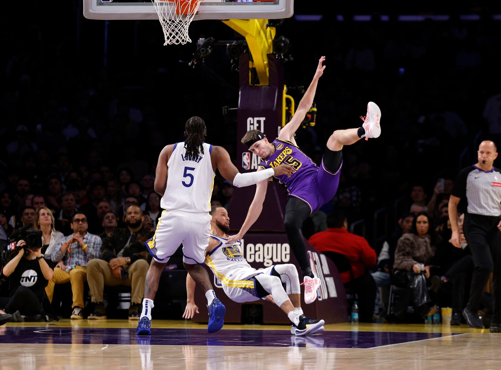 Los Angeles Lakers guard Austin Reaves, center right, collides with Golden State Warriors guard Stephen Curry, center left, during the first half of an NBA basketball game Thursday, Feb. 6, 2025, in Los Angeles. (AP Photo/Kevork Djansezian)