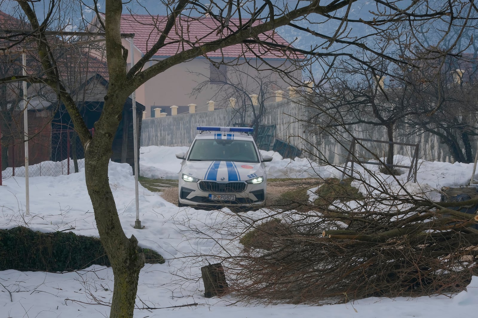 A police car outside a house after a shooting incident, in Cetinje, 36 kilometers (22 miles) west of Podogrica, Montenegro, Thursday, Jan. 2, 2025. (AP Photo/Risto Bozovic)