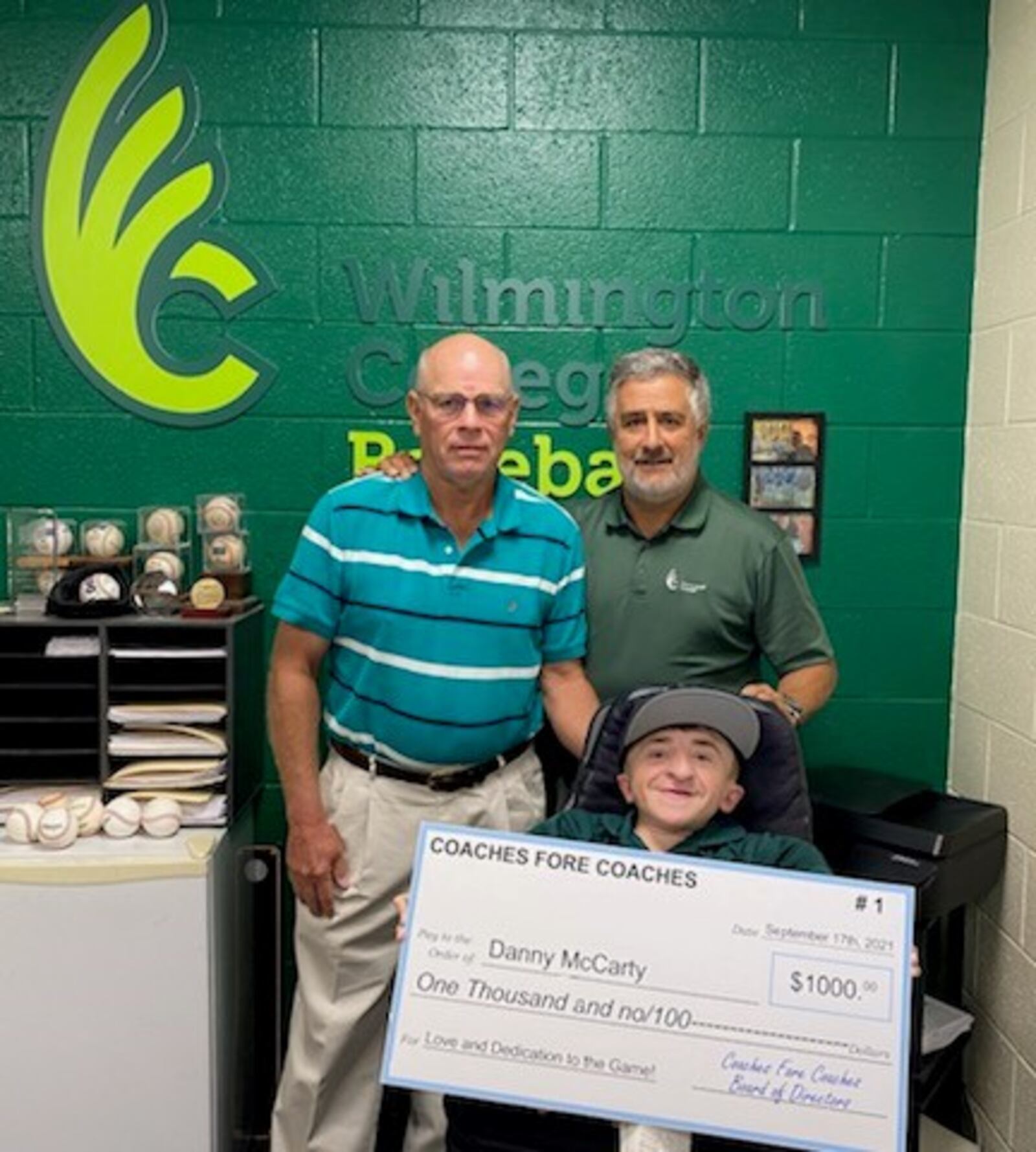 Wilmington college coach Tony Vittorio (standing right) and Paul Page, the Ohio Dominican University head baseball coach and director of Coaches Fore Coaches, with Fightin’ Quakers assistant baseball coach Daniel “Danny” McCarty, who received a $1,000 check as the inaugural winner of the Coaches Fore Coaches Award that supports small college baseball in Ohio and aids assistant coaches and grad assistants who have made an impact in the game and could use some assistance.(Contributed Photo)