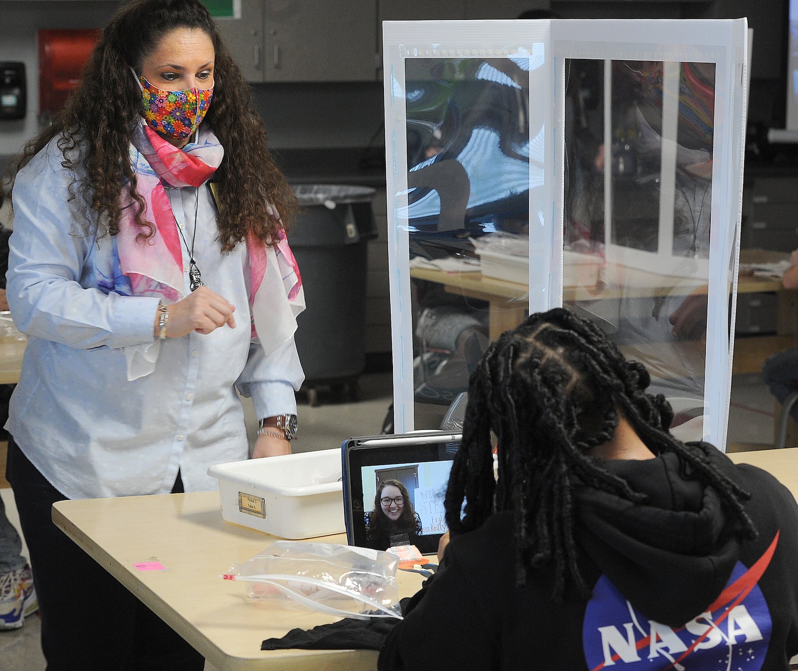 Stebbins art teacher Joan Miller (left) discusses a clay art project with student Stefani Miller-Brown on Thursday, Oct. 22. On the desk is an iPad, via which student-teacher Hannah Kelly works with Miller-Brown, even though Kelly is at home in Fremont, outside Toledo. MARSHALL GORBY\STAFF