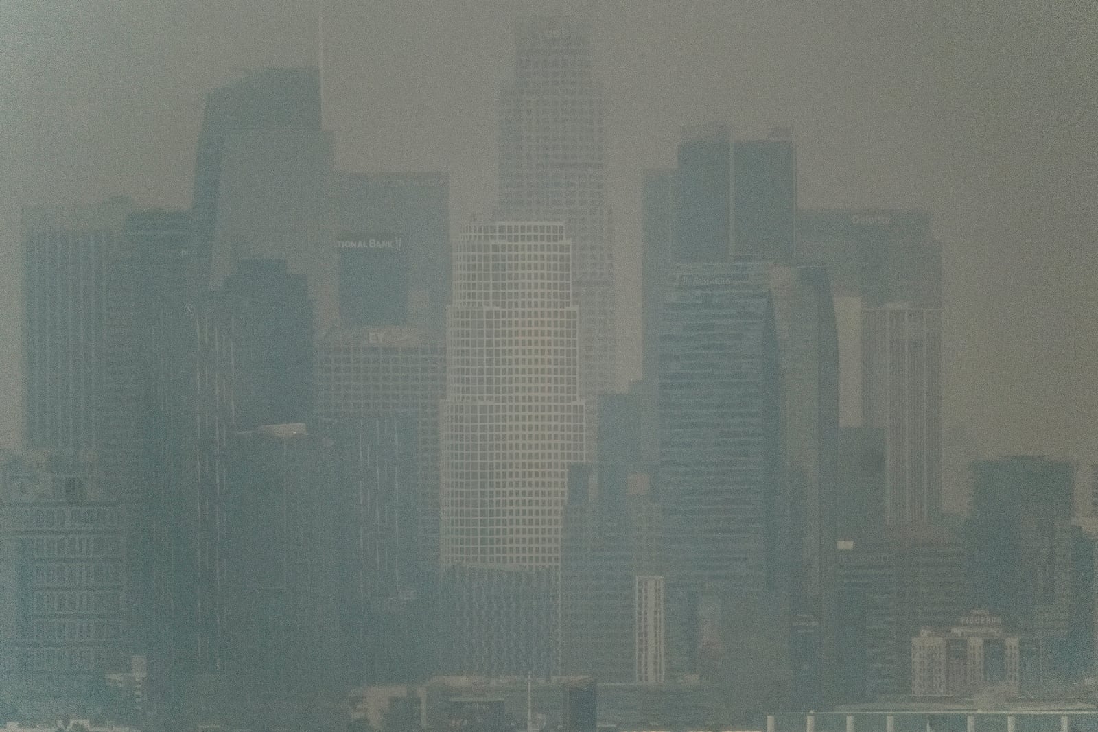 Thick heavy black smoke from wildfires shrouds buildings in downtown Los Angeles on Wednesday, Jan. 8, 2025. (AP Photo/Richard Vogel)