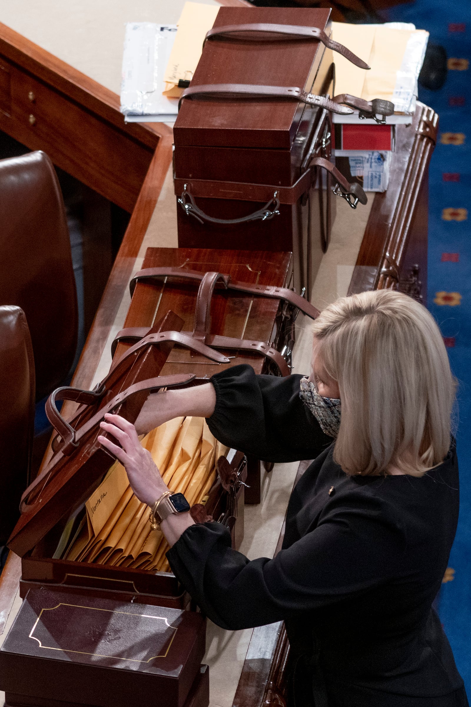 FILE - Boxes containing Electoral College votes are opened as a joint session of the House and Senate convenes to confirm the electoral votes cast in November's election, at the Capitol, Jan 6, 2021. (AP Photo/Andrew Harnik, File)