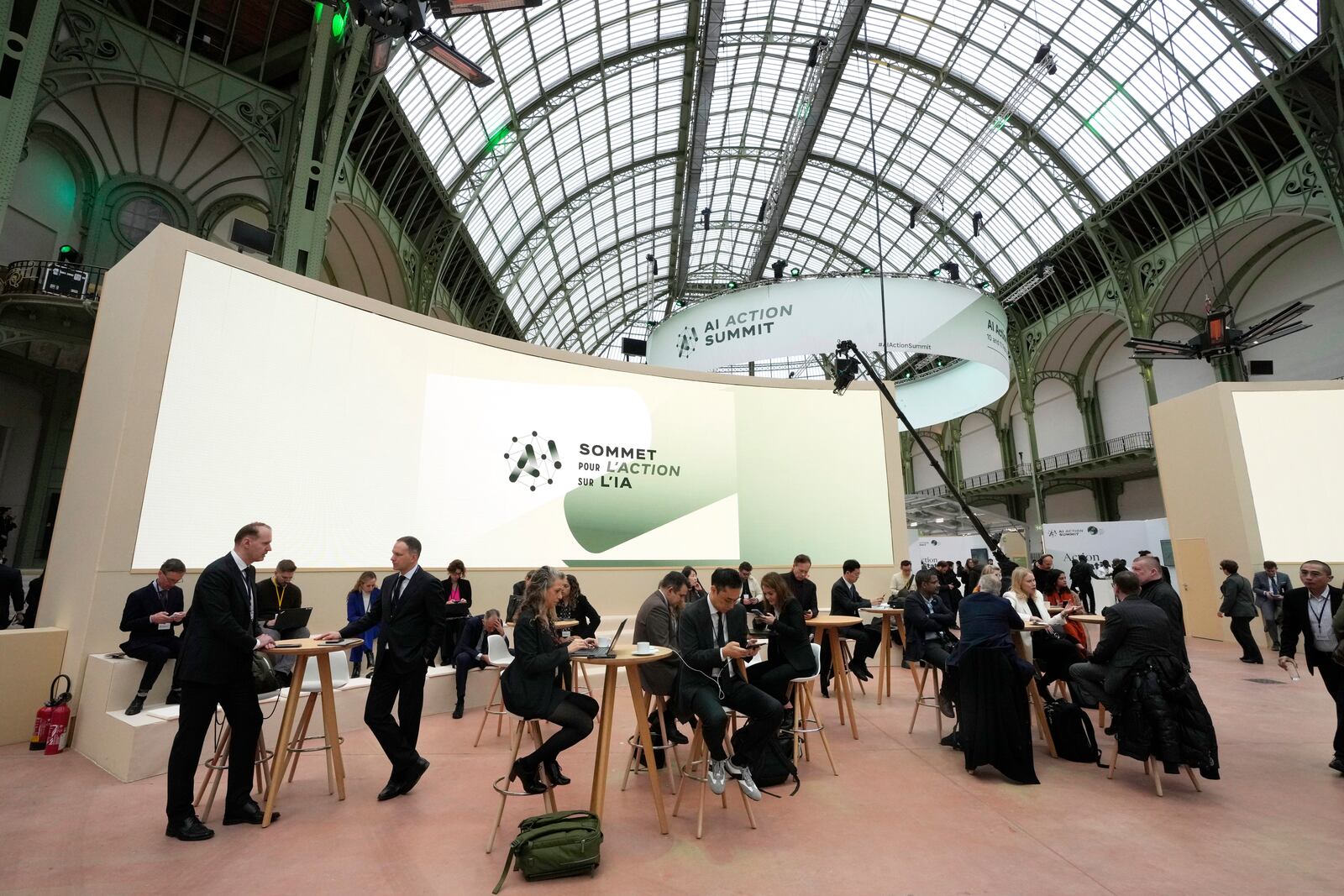 Attendees gather in a common space during an Artificial Intelligence Action Summit at the Grand Palais in Paris, Monday, Feb. 10, 2025. (AP Photo/Michel Euler)