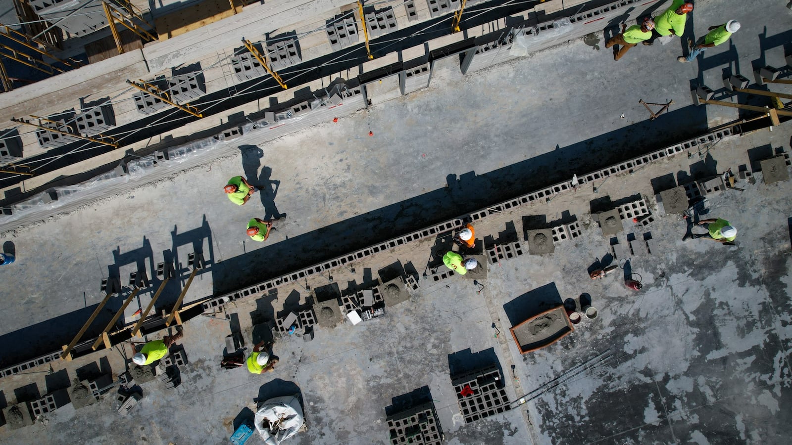 Workers build walls for West Carrollton school district's new middle/high school campus along Interstate 75. When completed in 2026, it will house seventh through 12th-grade students. JIM NOELKER/STAFF